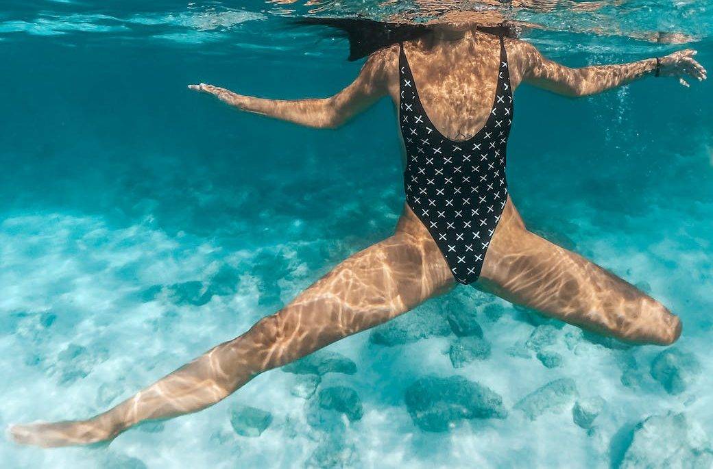 girl in black printed swimsuit in water